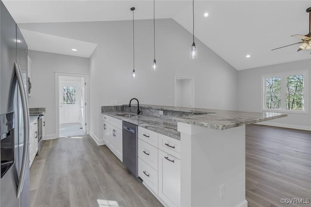 kitchen with a sink, a peninsula, a wealth of natural light, and stainless steel appliances