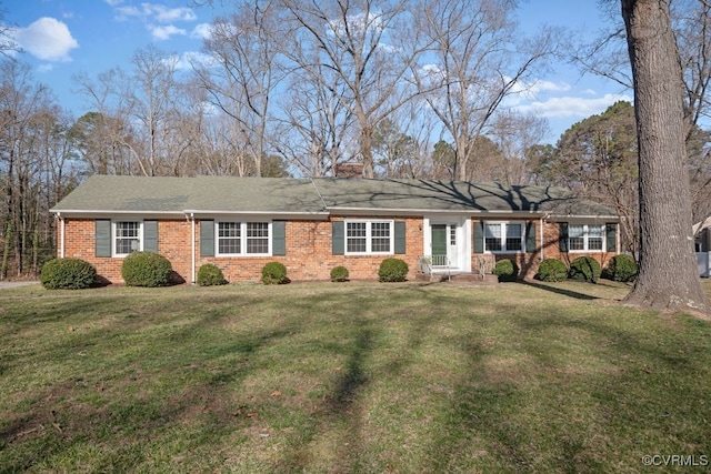 ranch-style house featuring brick siding, a chimney, and a front lawn