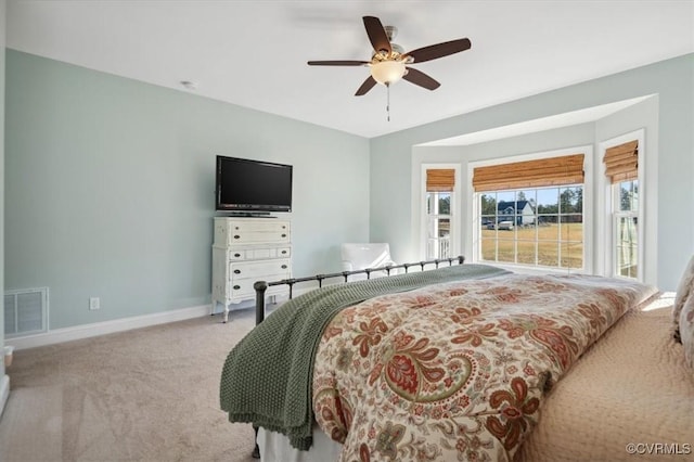 carpeted bedroom featuring visible vents, ceiling fan, and baseboards