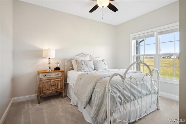 bedroom with light carpet, ceiling fan, and baseboards