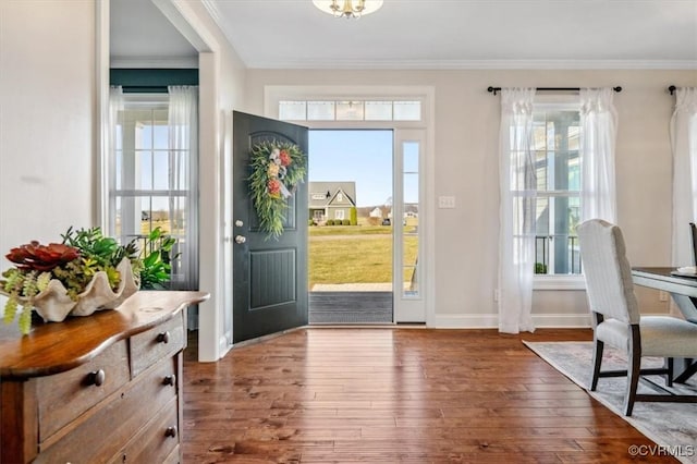 foyer entrance with baseboards, crown molding, and hardwood / wood-style flooring