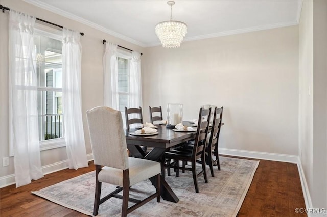 dining room with crown molding, a notable chandelier, wood finished floors, and baseboards