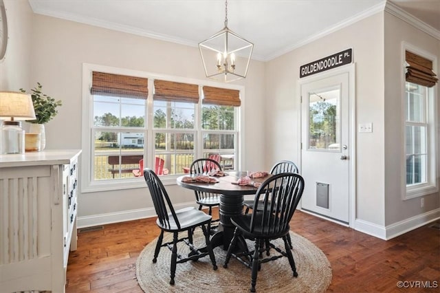 dining room with baseboards, wood-type flooring, a healthy amount of sunlight, and crown molding