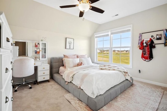 bedroom featuring visible vents, baseboards, vaulted ceiling, light carpet, and a ceiling fan