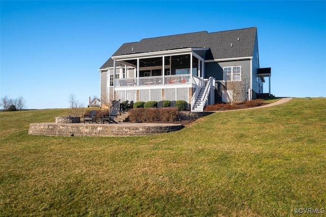 back of property with a lawn and stairs