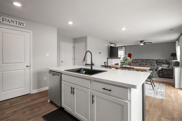 kitchen featuring dishwasher, wood finished floors, white cabinetry, and a sink