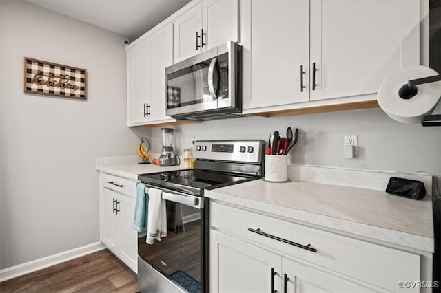 kitchen featuring white cabinetry, appliances with stainless steel finishes, light countertops, baseboards, and dark wood-style flooring