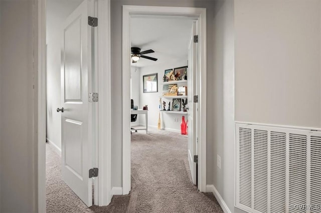 hall with carpet flooring, baseboards, and visible vents