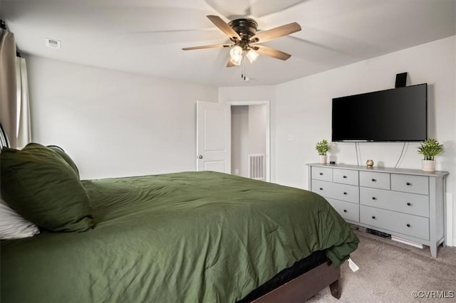 bedroom featuring a ceiling fan, visible vents, and light carpet