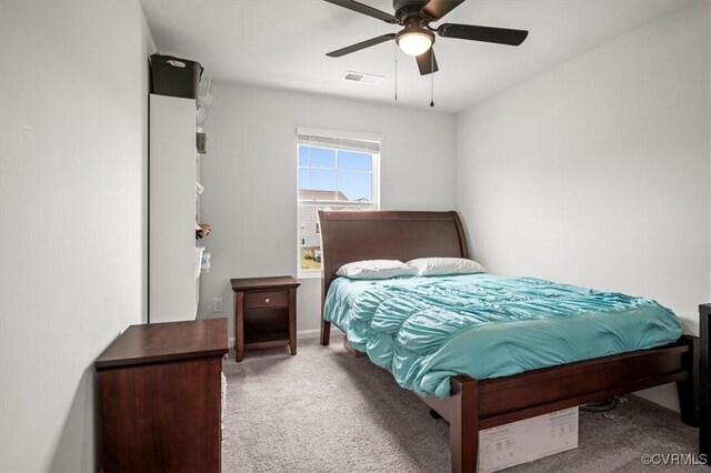 carpeted bedroom featuring a ceiling fan and visible vents