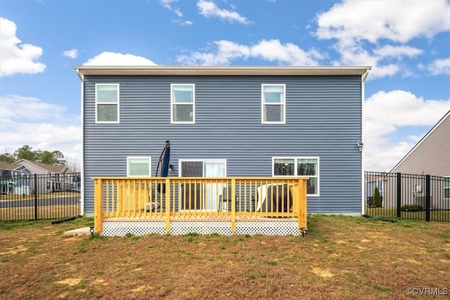 rear view of property featuring a deck, fence, and a lawn