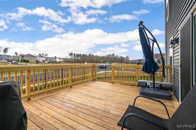 wooden terrace with a residential view and a grill