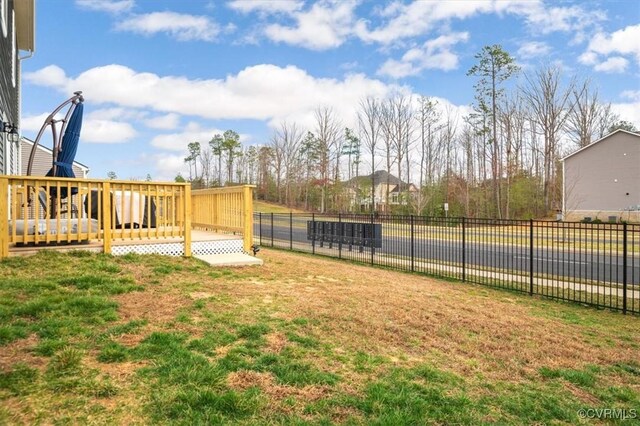 view of yard featuring fence and a wooden deck