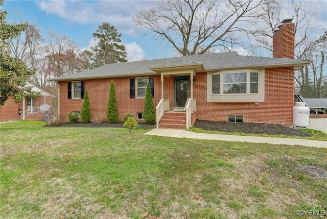 single story home with brick siding, a chimney, a front yard, and a shingled roof