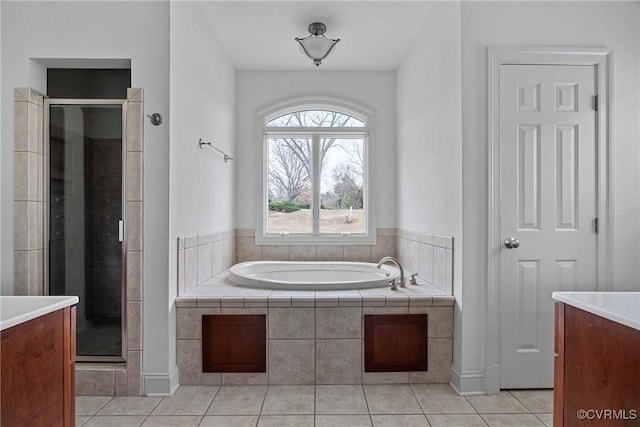 full bathroom with tile patterned floors, a stall shower, vanity, and a garden tub