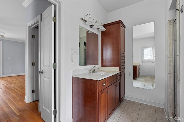 bathroom featuring tile patterned floors, baseboards, and vanity