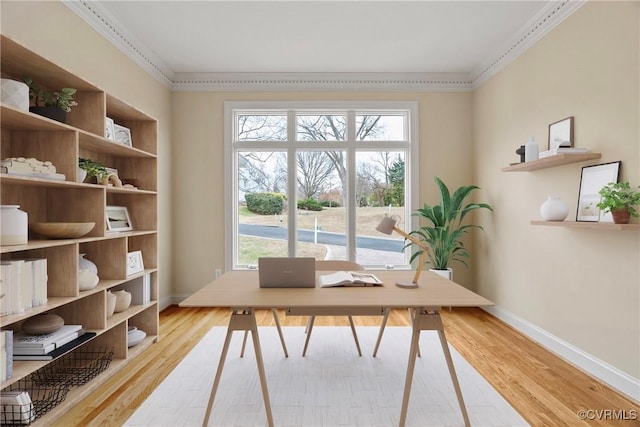 office featuring baseboards, crown molding, and light wood-style floors