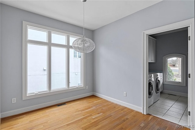 unfurnished dining area featuring light wood-type flooring, baseboards, independent washer and dryer, and visible vents