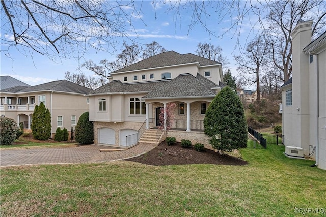 view of front facade featuring a front lawn, decorative driveway, a porch, roof with shingles, and a garage