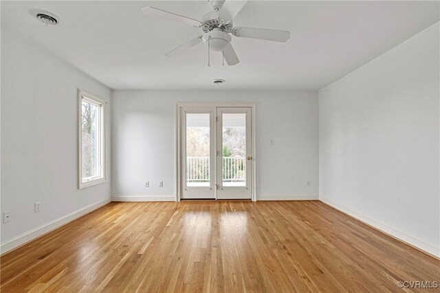 unfurnished room with a wealth of natural light, visible vents, light wood-type flooring, and baseboards