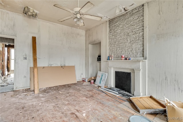 unfurnished living room featuring a ceiling fan and a fireplace