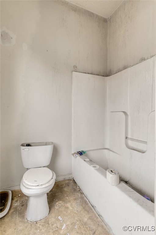 full bath featuring toilet, baseboards, and a tub