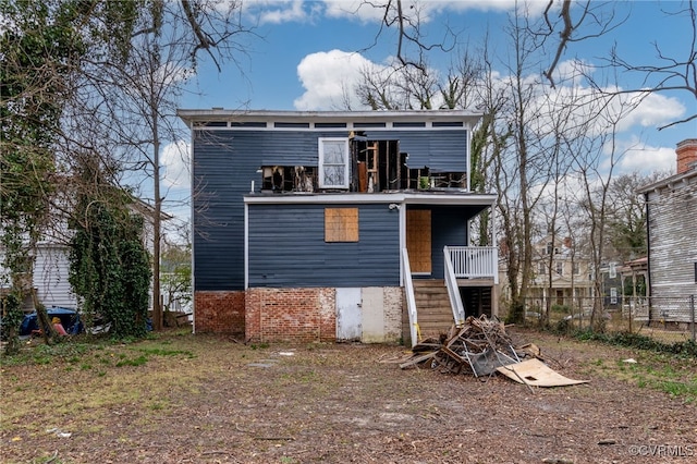 rear view of house with stairway and a balcony