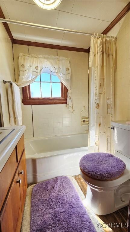 full bath featuring wood finished floors, toilet, vanity, and shower / bathtub combination with curtain