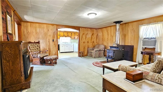 carpeted living room featuring cooling unit, wood walls, a fireplace, a wood stove, and washing machine and clothes dryer