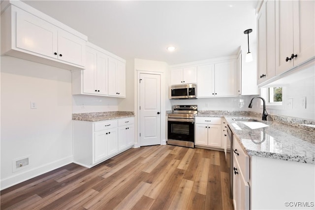 kitchen featuring white cabinetry, light wood-style flooring, appliances with stainless steel finishes, and a sink