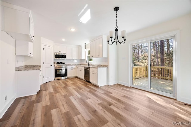 kitchen with light wood-style flooring, a healthy amount of sunlight, and appliances with stainless steel finishes