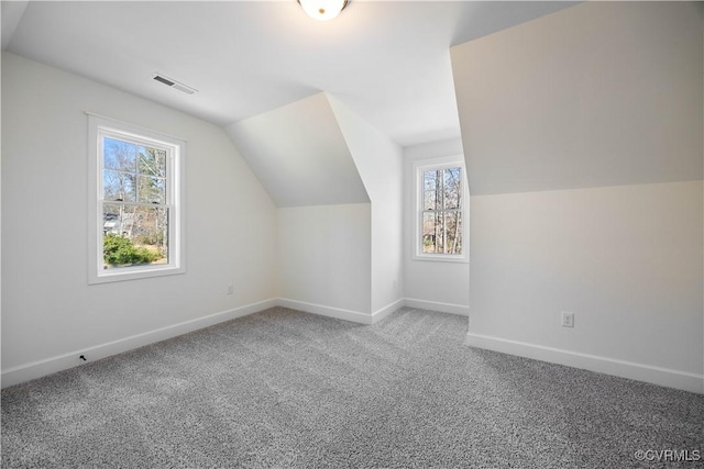 bonus room featuring visible vents, plenty of natural light, carpet, and vaulted ceiling