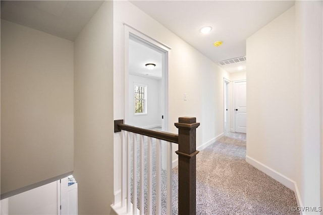 corridor with visible vents, baseboards, recessed lighting, an upstairs landing, and light colored carpet