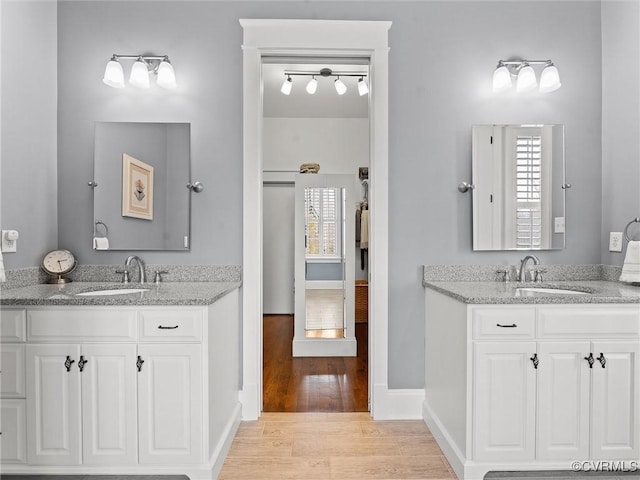 bathroom with a sink, a healthy amount of sunlight, and wood finished floors