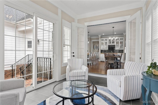 tiled living area featuring crown molding and an inviting chandelier