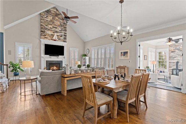 dining space featuring wood finished floors, a healthy amount of sunlight, and a warm lit fireplace