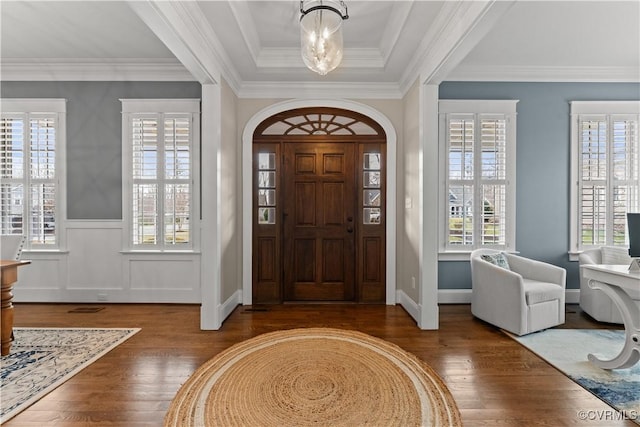 entrance foyer with a notable chandelier, a healthy amount of sunlight, and wood finished floors