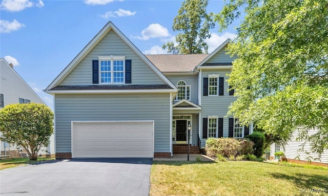 view of front facade with aphalt driveway, a garage, and a front yard