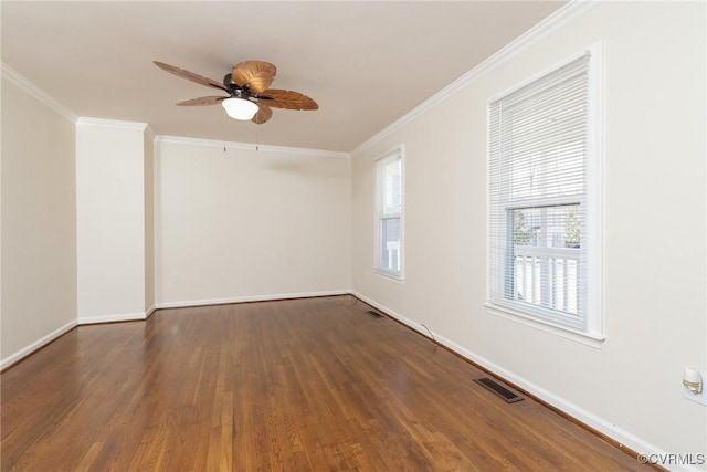 spare room featuring crown molding, wood finished floors, visible vents, and baseboards