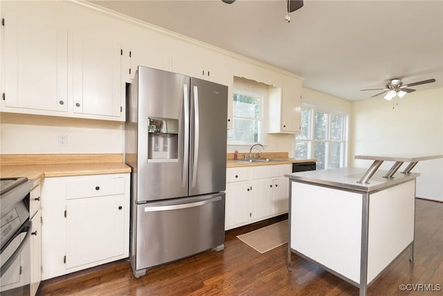 kitchen featuring a sink, stainless steel fridge, a ceiling fan, and white cabinetry