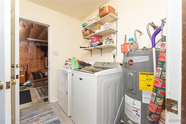 washroom featuring electric water heater, washing machine and dryer, and laundry area