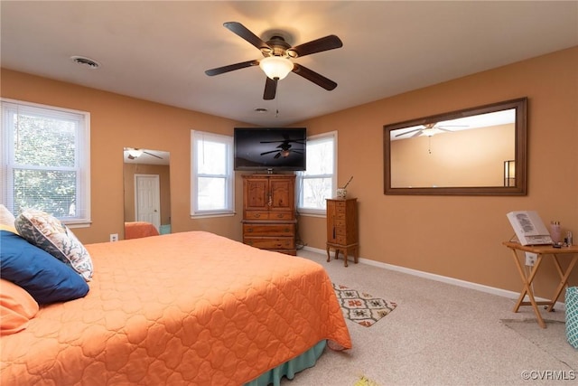 carpeted bedroom with visible vents, baseboards, and a ceiling fan