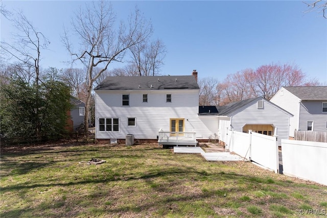 back of property featuring a lawn, a fenced backyard, cooling unit, a wooden deck, and a chimney