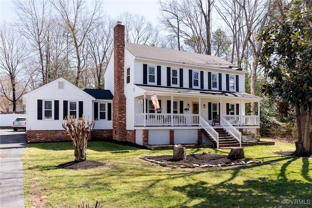 view of front of property featuring a porch, a chimney, and a front yard