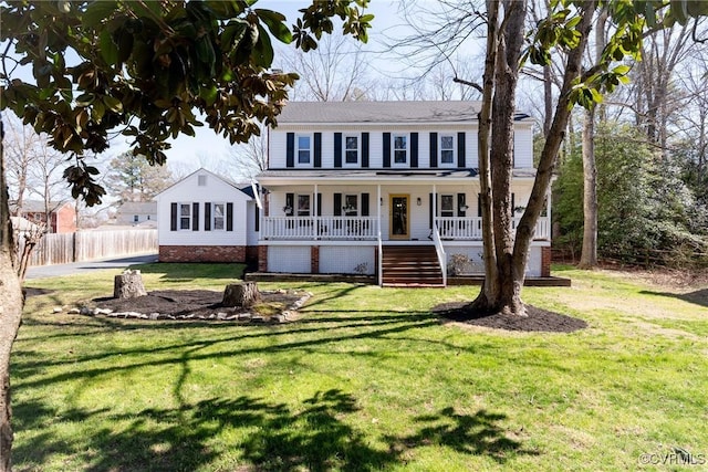 view of front facade with covered porch, a front lawn, and fence