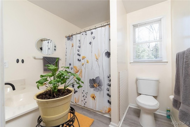 bathroom with curtained shower, toilet, and baseboards