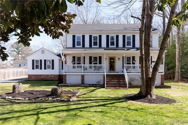 colonial house with a porch, stairway, and a front yard