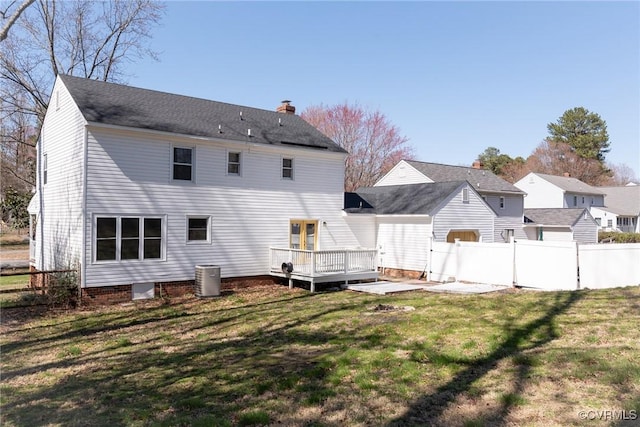 rear view of property featuring a lawn, cooling unit, a deck, and fence