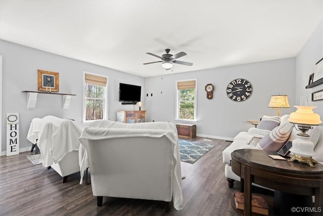 living area featuring baseboards, plenty of natural light, and dark wood finished floors