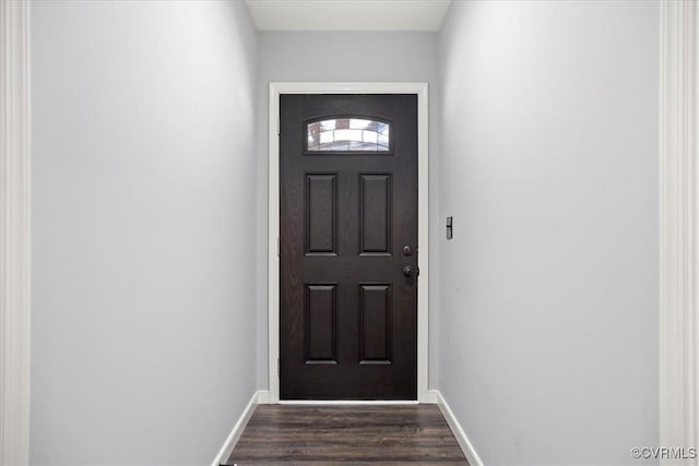 doorway to outside with dark wood finished floors and baseboards